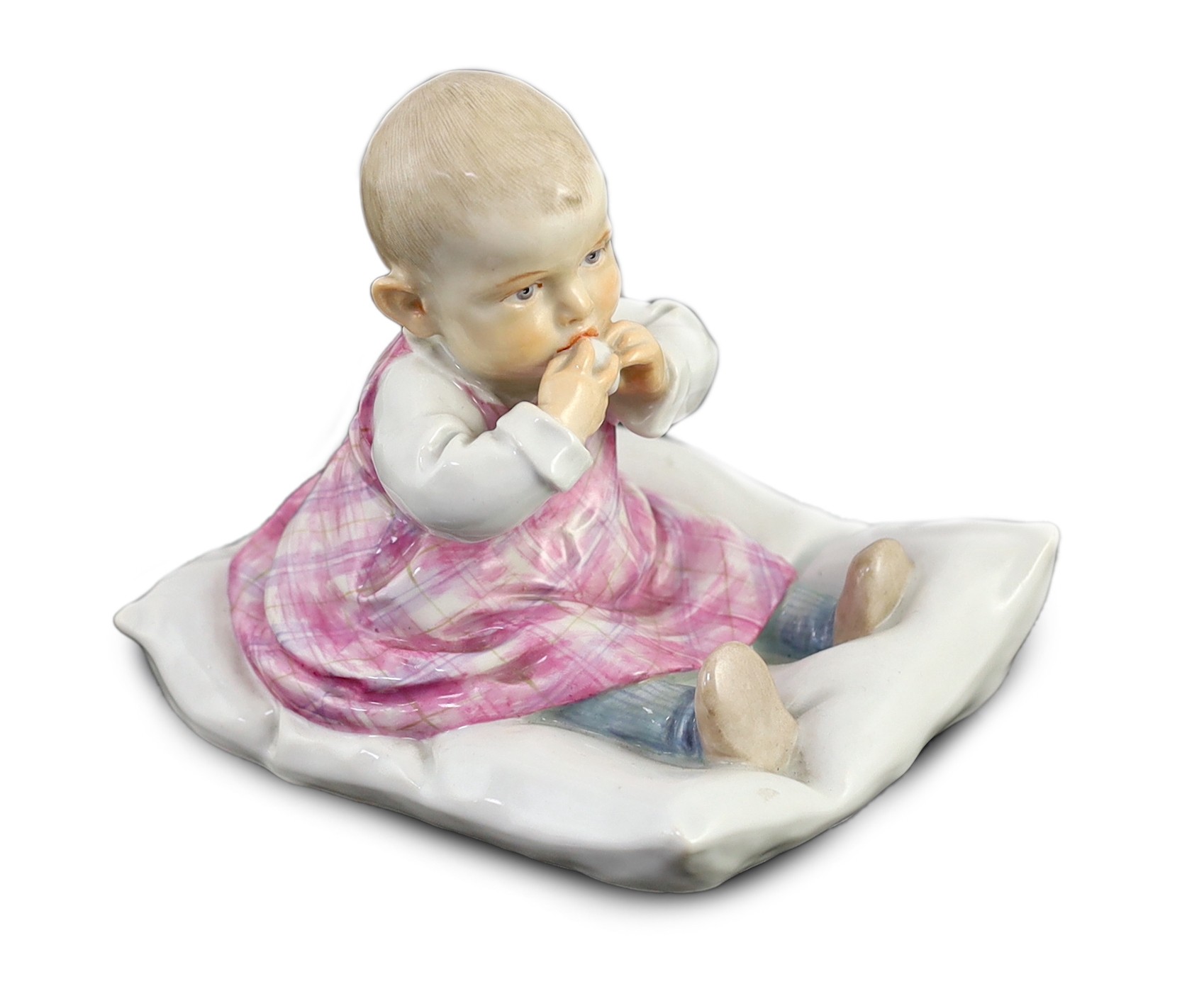 A rare Meissen porcelain figure of a child on a pillow, designed by Conrad Hentschel, c.1905, 12.5cm high
